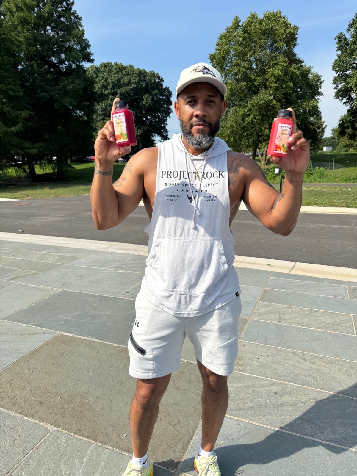 Client holding two fresh-pressed watermelon juices after a workout